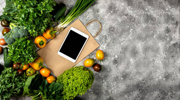 istock Different vegetables with tablet computer and shopping paper bag. Banner Top view with place for text. 1284413806