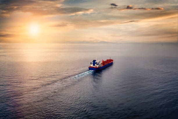 istock A cargo ship sailing over calm sea into the sunset 1284416227