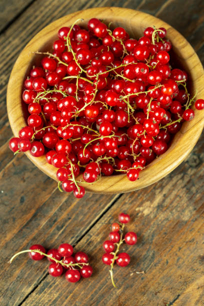 istock Sweet fresh red currant in a plate on wood table. 1284417688