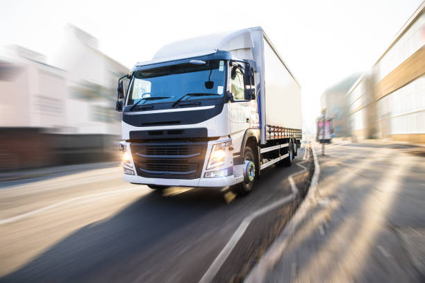 a white truck travels along a road