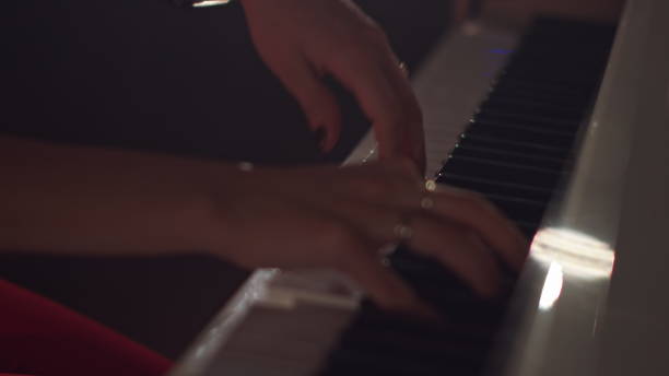 istock A female young hands playing piano in black manicure and accessories. Classical music pattern. Girl playing piano keywords 1284420983