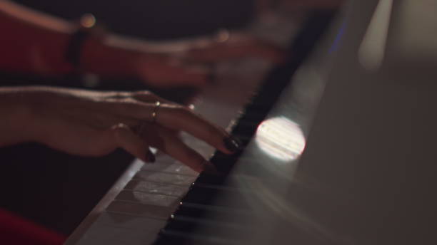 istock A female young hands playing piano in black manicure and accessories. Classical music pattern. Girl playing piano keywords 1284420986