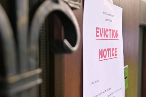 the notice of eviction of tenants hangs on the door of the house the notice of eviction of tenants hangs on the door of the house, front view eviction stock pictures, royalty-free photos & images
