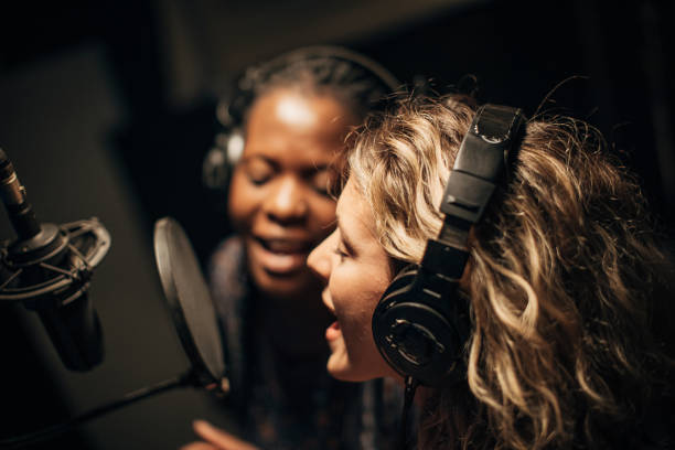 istock Two female singers singing a duet in recording studio together 1284427566