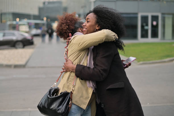 istock Two young black women hugging on the street 1284429989