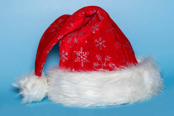 istock Red and white santa hat shot on a blue background 1284435541