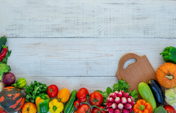 istock vegetables on white wooden background with cutting board 1284435830