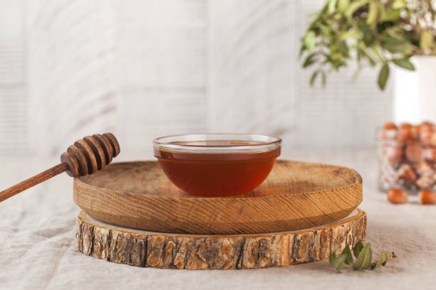 brown honey in a glass bowl on a rustic wooden plate. copy space. - sweet food chestnut yellow brown imagens e fotografias de stock