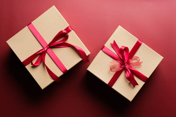 istock Gift boxes with red ribbon bow on marsala red background. Christmas present, valentine day surprise, birthday concept. Flat lay, top view. 1284439642