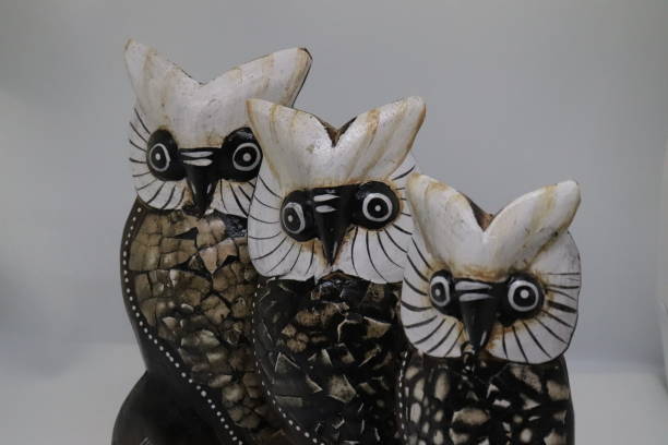 istock three wooden owl figures on white background 1284440187