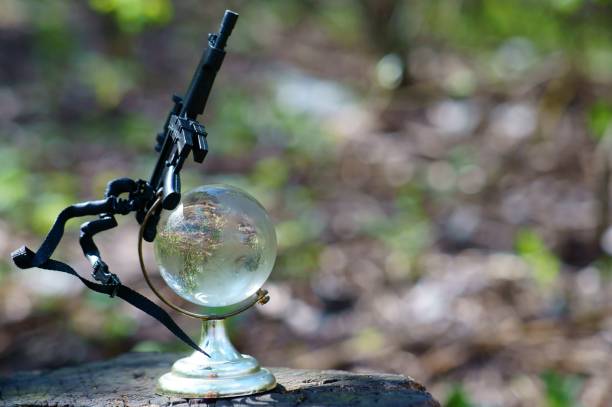 istock A small glass globe with a toy weapon. 1284441706