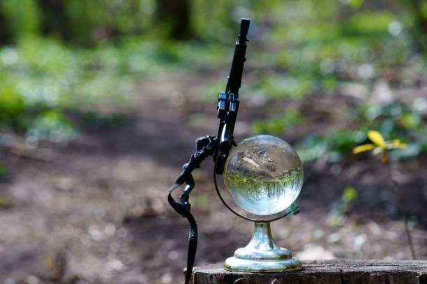 istock A small glass globe with a toy weapon. 1284441771