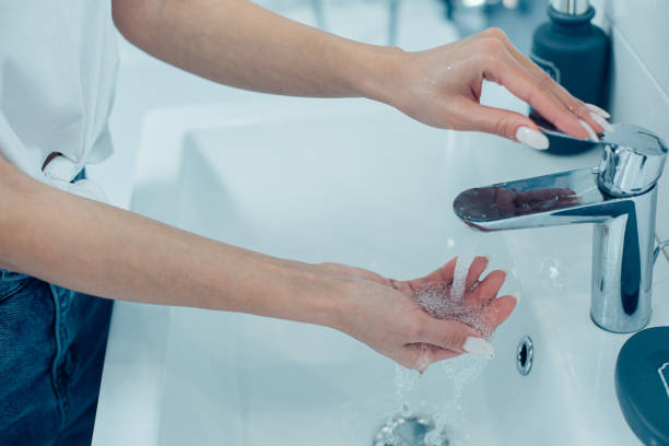 istock Female using the bathroom tap for hygienic needs 1284445315