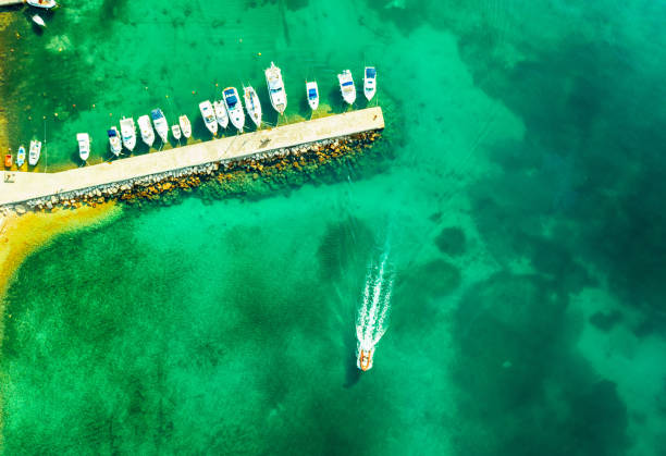 Aerial view of amazing boats in Croatia. Minimalistic landscape background with boats and sea in marina bay. Top view from drone of harbor with yacht, motorboat and sailboat. Beautiful port