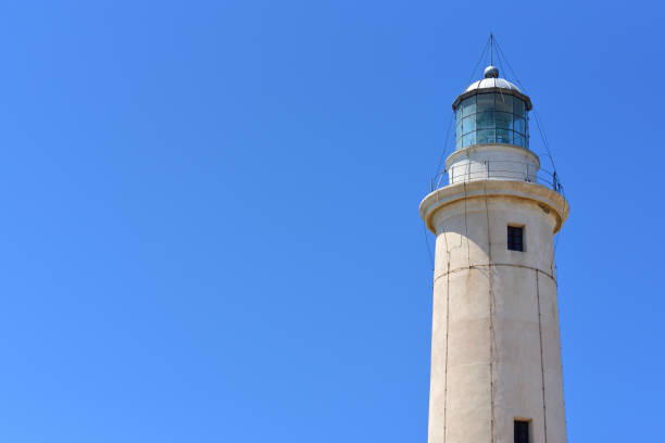 Close up of the top of a lighthouse, to the side of the picture, against a blue sky Close up of the top of a lighthouse, to the side of the picture, against a blue sky lightning tower stock pictures, royalty-free photos & images