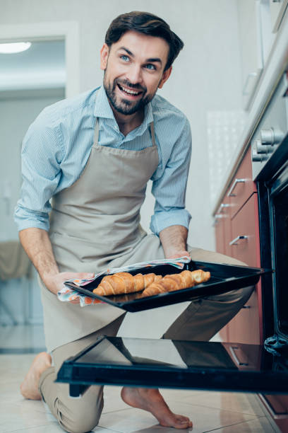 istock Barefooted young man looking proud of his baking skills 1284445899