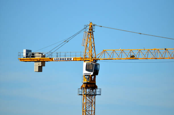 Tower crane Liebherr constructing a new residential building at a construction site against blue sky. Russia, Moscoe - July 23, 2019