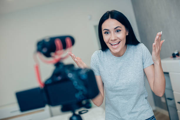 istock Pretty video blogger putting hands up in excitement 1284446732