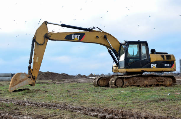 Excavators and a trucks at construction site seen from far