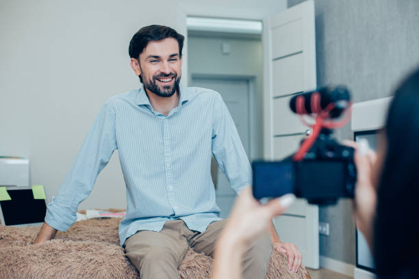 istock Pleased young man giving friendly interview on the camera 1284447162