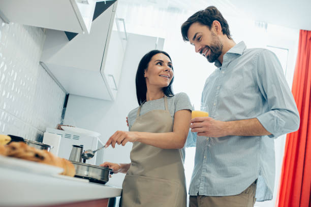 istock Happy couple cooking at home together and looking glad 1284448521