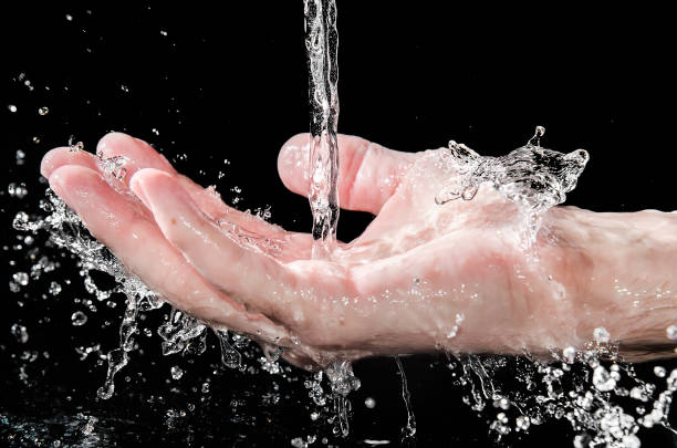 istock Men hand in water splash on the black background, selected focus 1284449239