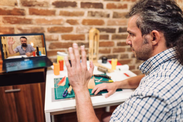 istock Craftsman working in his studio and talking in video chat 1284449373