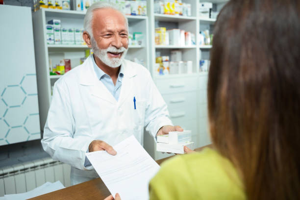 istock Senior pharmacist giving medications to a female customer 1284450744