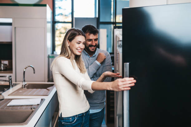 pareja joven en compras - small appliance fotografías e imágenes de stock