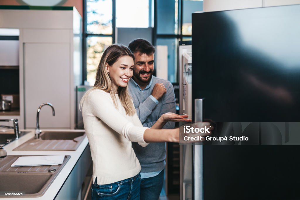 Young couple in shopping Happy young couple buying household appliances in store. Appliance Stock Photo