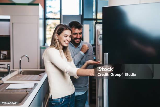 Young Couple In Shopping Stock Photo - Download Image Now - Appliance, Sale, Couple - Relationship