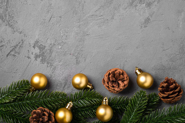 istock Christmas composition. Golden baubles, pine cones and fir needles decorations on grey background. Top view copy space 1284459983