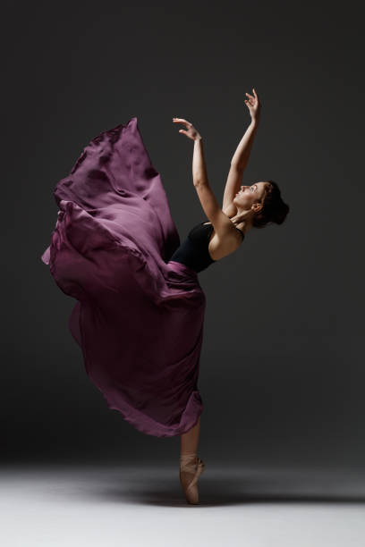 istock Young beautiful ballerina is posing in studio 1284460754