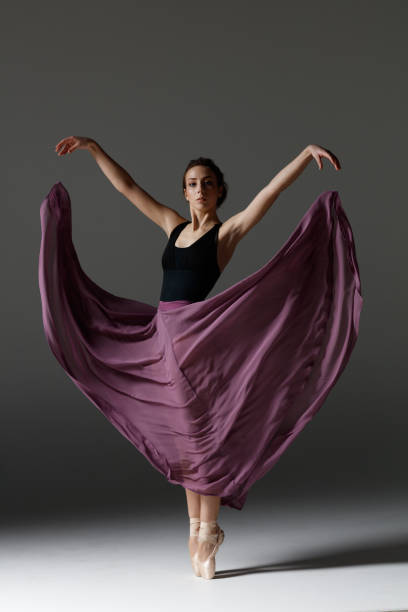 istock Young beautiful ballerina is posing in studio 1284461024