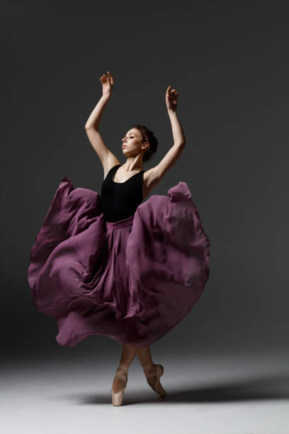 istock Young beautiful ballerina is posing in studio 1284461171