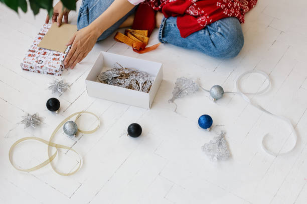 istock Woman decorating christmas present on floor 1284461944