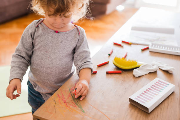 istock Toddler using wax colors on furniture 1284462729