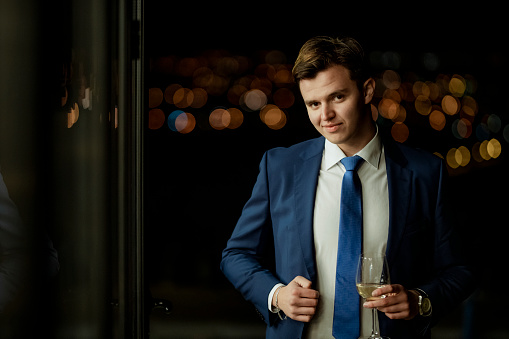A portrait of a handsome young businessman who is outside on a beautiful night. Portrait of a confident businessman in an elegant suit