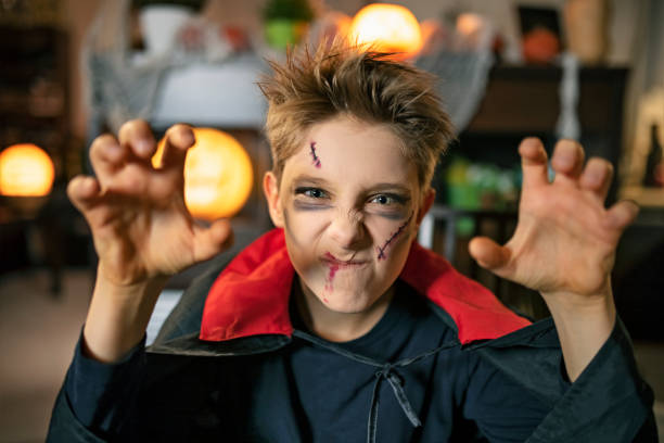 Young boy in halloween costume showing teeth and holding eyes