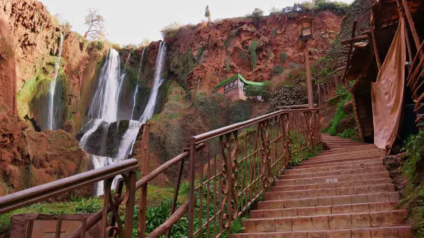 Photo of Stairs with a metal railing with a lantern leading up to a viewpoint on Ouzoud Falls near Ouzoud, Morocco.