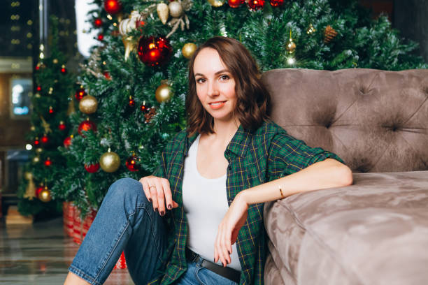 istock Young beautiful brunette woman at the Christmas tree 1284470748