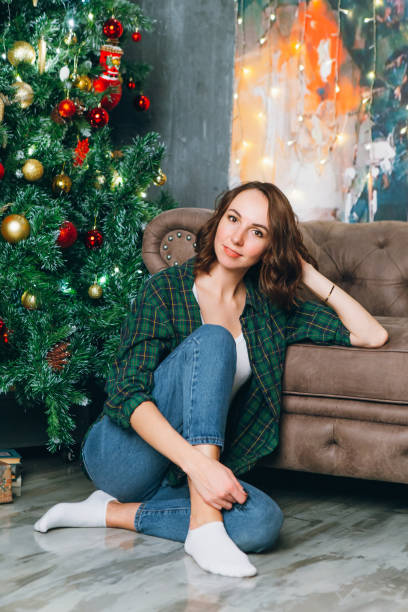 istock Young beautiful brunette woman at the Christmas tree 1284470752