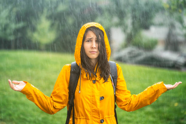 mädchen steht nass unter dem regen - drenched raincoat rain clothing stock-fotos und bilder