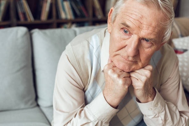 istock Senior man alone sitting at library looking out the window curious 1284472447