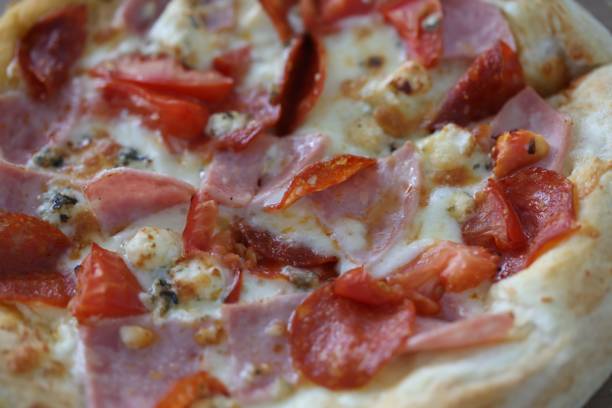 istock Pizza with cheese, ham, sausage, spices and tomato sauce closeup 1284472768