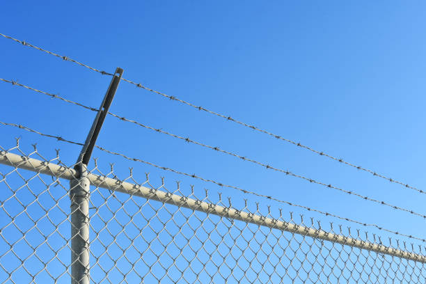 istock Industrial Fence with Barbed Wire 1284473357