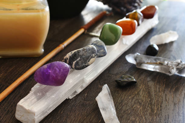 Healing Chakra Crystals Close Up A close up image of seven chakra healing crystals charging on a selenite wand. chakra recovery energy gem stock pictures, royalty-free photos & images