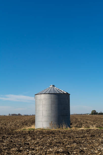 istock Solitary grain silo on a barren field. 1284474941