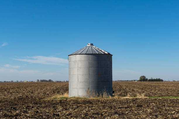 istock Solitary grain silo on a barren field. 1284474942
