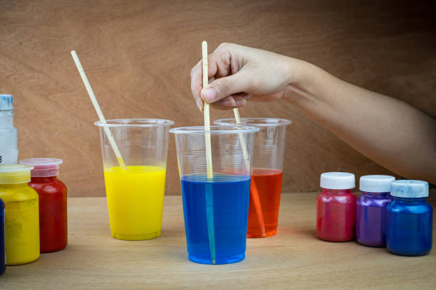 Mixing color epoxy resin in a plastic cup for casting stabilizing wood Mixing color epoxy resin in plastic cup for casting Stabilizing wood and pine cone hybrid craft resin stock pictures, royalty-free photos & images